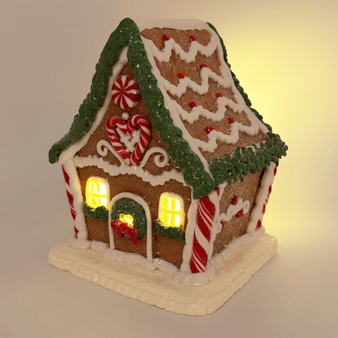 Lit Gingerbread House with Pine Frosting Garland
